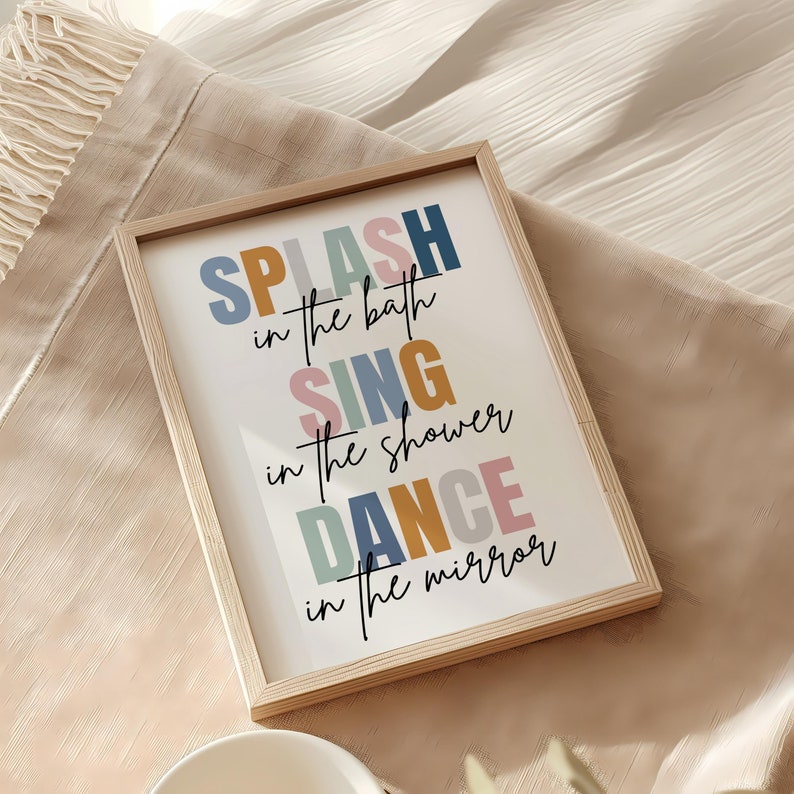 以下が含まれることがあります： カラフルなスタイリッシュな文字で「SPLASH in the bath SING in the shower DANCE in the mirror」と書かれた額装されたプリントです。
