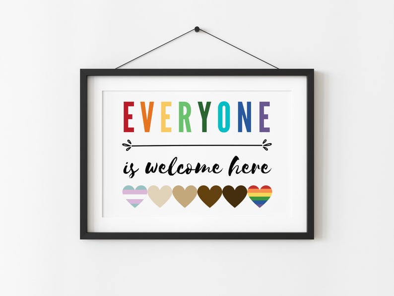 May include: A framed print with the text "EVERYONE is welcome here" in rainbow colors. The print features a row of seven hearts in different colors and patterns, including a rainbow heart, a transgender pride heart, and a brown heart.
