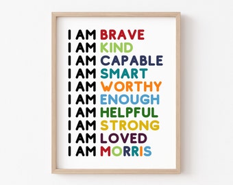 May include: A framed print with the text "I AM" followed by a list of positive affirmations in different colors: brave, kind, capable, smart, worthy, enough, helpful, strong, loved, and Morris.