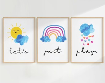 May include: Three framed prints with watercolor illustrations of a sun, a rainbow, and a cloud with hearts. The text "let's just play." is written below the images.