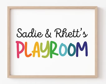 May include: A framed print with the text "Sadie & Rhett's PLAYROOM" in colorful rainbow letters. The text is in a playful, handwritten font.