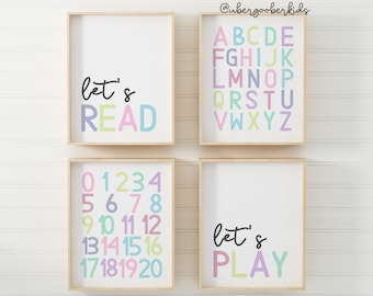 May include: Four framed prints with a white background and colorful text. The top left print says "let's READ" in pink, green, and blue. The top right print has the alphabet in rainbow colors. The bottom left print has the numbers 0-20 in rainbow colors. The bottom right print says "let's PLAY" in pink, green, and blue.