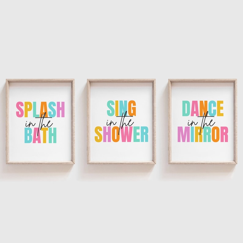 May include: Three framed prints with colorful text. The first print says "Splash in the Bath" in orange, pink, blue, and yellow. The second print says "Sing in the Shower" in orange, pink, blue, and yellow. The third print says "Dance in the Mirror" in orange, pink, blue, and yellow.