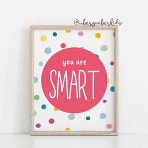 May include: A white framed print with a pink circle in the centre that says "you are SMART" in white text. The background is white with colourful polka dots.