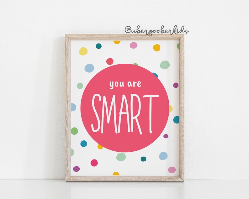 May include: A white framed print with a pink circle in the centre that says "you are SMART" in white text. The background is white with colourful polka dots.