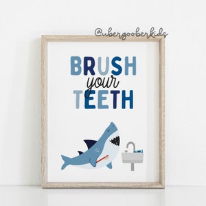 May include: A blue and white printable poster with a shark holding a toothbrush and the text "BRUSH your TEETH".