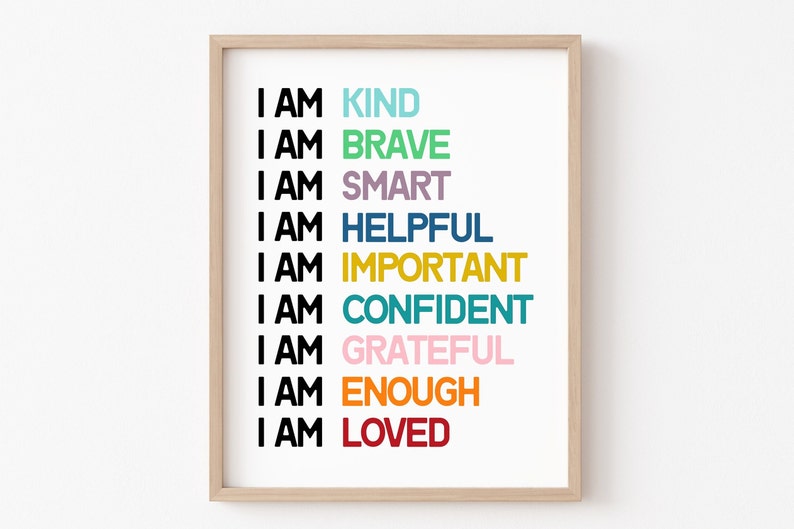 May include: A framed print with the text "I AM" followed by a list of positive affirmations in different colors: KIND, BRAVE, SMART, HELPFUL, IMPORTANT, CONFIDENT, GRATEFUL, ENOUGH, LOVED.