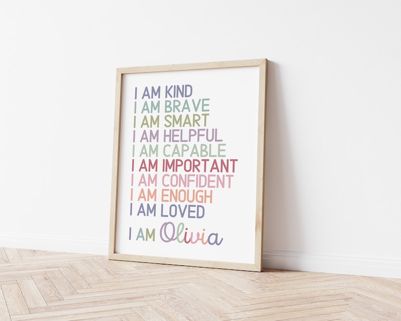 May include: A framed print with the text "I am kind, I am brave, I am smart, I am helpful, I am capable, I am important, I am confident, I am enough, I am loved, I am Olivia" in various pastel colors.