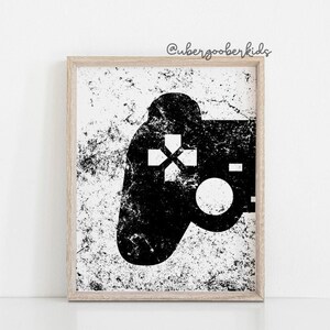 May include: Black and white illustration of a video game controller with a distressed background. The controller is in the shape of a traditional gamepad with a directional pad, buttons, and a joystick. The background is a white surface with black speckles.