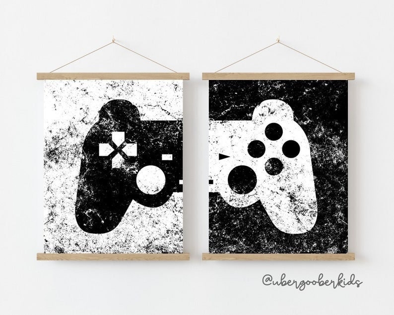 May include: Two black and white prints of a video game controller on a white background. The controller on the left is black with a white background and the controller on the right is white with a black background.