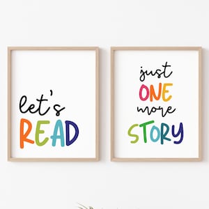May include: Two framed prints with colorful text. The left print says "let's READ" in rainbow colors. The right print says "just ONE more STORY" in rainbow colors.