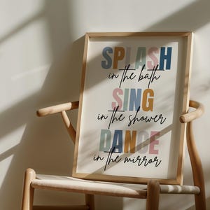 以下が含まれることがあります： 白い背景にカラフルな文字で「SPLASH in the bath SING in the shower DANCE in the mirror」と書かれた額装されたプリントです。