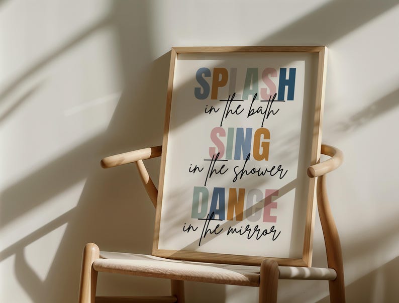 以下が含まれることがあります： 白い背景にカラフルな文字で「SPLASH in the bath SING in the shower DANCE in the mirror」と書かれた額装されたプリントです。