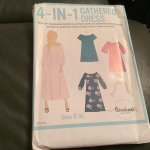 May include: A sewing pattern titled "4-IN-1 GATHERED DRESS" with illustrations of different dress styles. The pattern includes sizes S-XL. The cover features a woman in a pink dress and the text "threadcount PATTERNS".