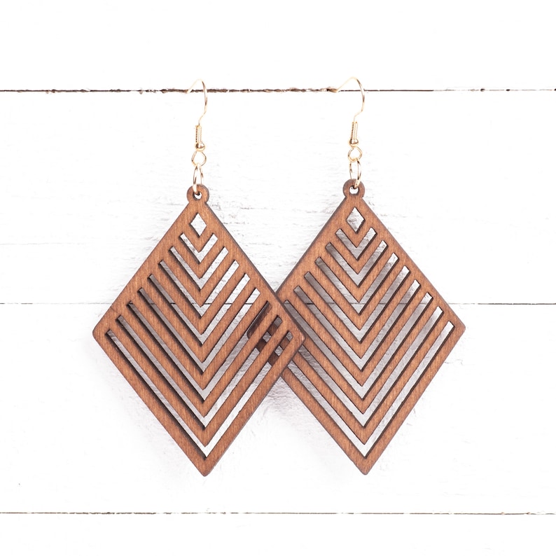 May include: A pair of brown wooden earrings with a geometric diamond shape and a chevron pattern.