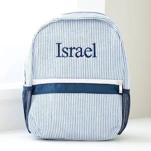 May include: Blue and white striped backpack with a navy blue trim and a zipper closure. The backpack is personalized with the name "Israel" in navy blue embroidery.