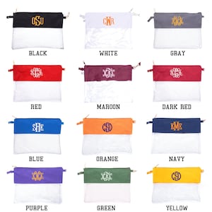 May include: Twelve clear zippered pouches with different colored fabric tops. The fabric tops are monogrammed with different letters. The colors of the fabric tops are black, white, gray, red, maroon, dark red, blue, orange, navy, purple, green, and yellow.