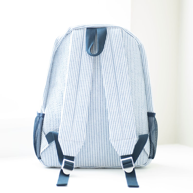 May include: A blue and white striped backpack with adjustable straps and mesh side pockets.