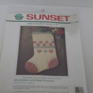 May include: A white and red patchwork Christmas stocking with a heart design. The pattern is called "Antiqued Quilts" and is from Sunset.