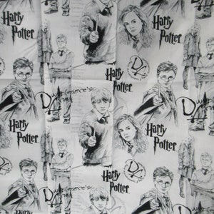 May include: White fabric featuring a repeating pattern of black and white illustrations of Harry Potter characters, the Harry Potter logo, and the text "Dumbledore's". The design includes images of Harry, Ron, and Hermione.