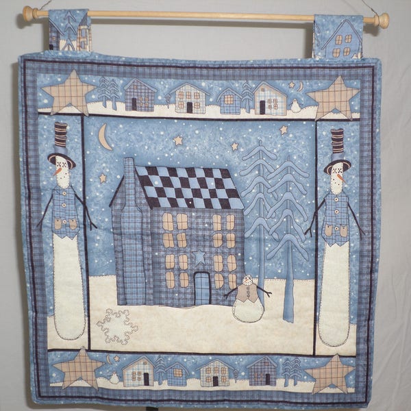 Snowman handmade wallhanging blue and cream 16 1/2 by 17 inches has snowman houses ans stars.