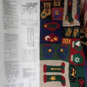 May include: A fabric panel for making Christmas ornaments, pillows, wall hangings, or a quilt. The panel features a variety of Christmas-themed designs, including mittens, stockings, stars, and the word "JOY". The color palette includes red, green, blue, and gold.