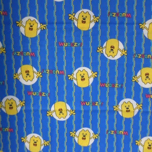 Blue Wubzzy Cartoon kids cotton quilt fabric to sew or craft  cute colorful fabric in a blue multicolor and there is 1 yard by 41 inches .