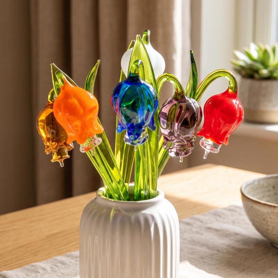 Six individually flameworked borosilicate glass bell-shaped flowers — each petal formed by a human hand at a torch, never wilting, never the same twice.