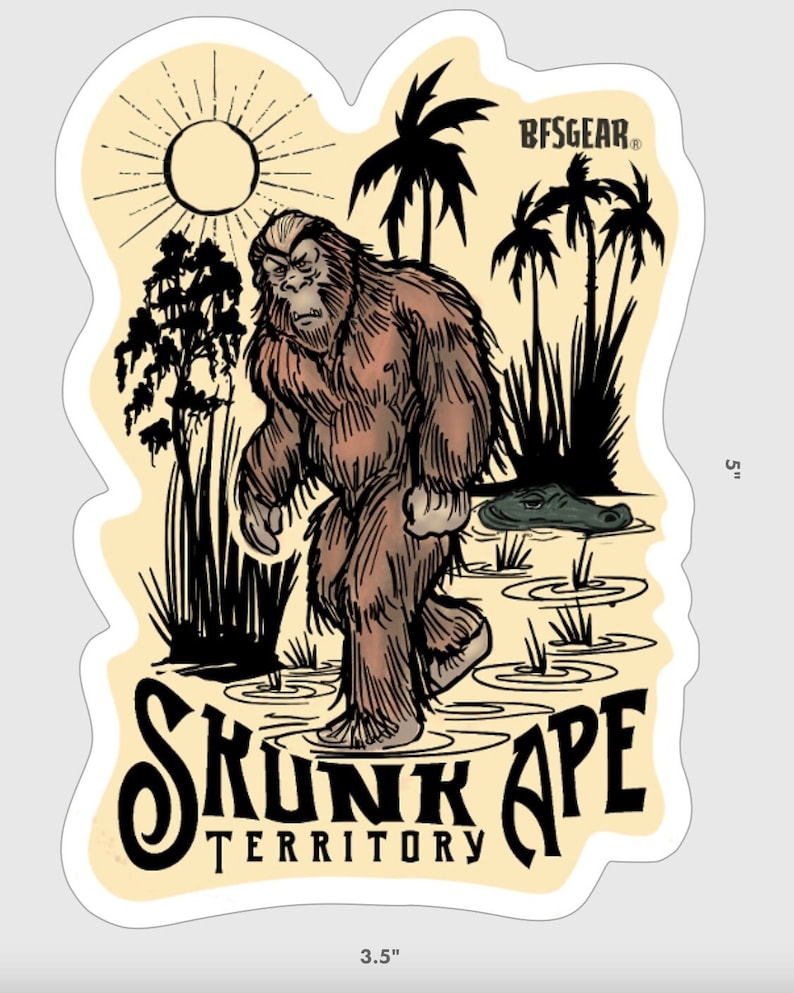 May include: A brown and black sticker with a cartoon illustration of a Bigfoot walking through a swamp. The sticker has the text "Skunk Ape Territory" and the logo "BFSGEAR" in the top right corner. The sticker is 5 inches tall and 3.5 inches wide.