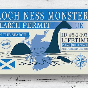 May include: A blue and white illustrated card with the text "Loch Ness Monster Search Permit" and "Join the Search". The card features a map of Scotland with a cartoon Nessie swimming in the water. The card also includes the text "ID #5-2-1933 LIFETIME PERMIT NO EXPIRATION AUTHORIZED USE ONLY".
