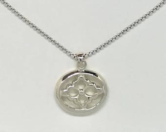 Sterling silver horizontal oval pendant with stylized flower center, 18 inch.