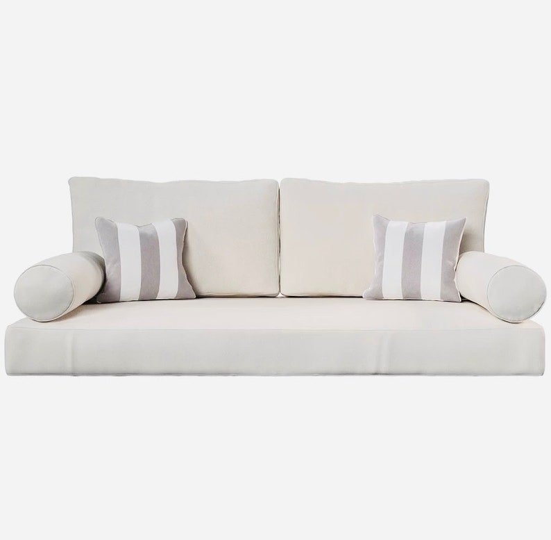 May include: A modern, off-white sofa with two square back cushions and two striped accent pillows. Two cylindrical bolsters are on either end. The pillows have gray and white stripes. The sofa is a neutral color.