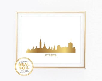 Könnte beinhalten: Ein gerahmter Druck mit einer Goldfolien-Silhouette der Skyline von Ottawa auf weißem Hintergrund. Das Wort "OTTAWA" ist darunter gedruckt. Ein goldener Aufkleber links unten lautet "MULTIPLE REAL FOIL COLORS AVAILABLE."
