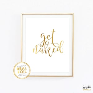 A gold foil wall art print with the words get naked in gold foil in a beautiful script font. A great piece of gold decor for a bedroom, bathroom, washroom and more.