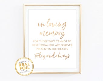 Puede incluir: Un letrero enmarcado con letras doradas que dice "in loving memory". El texto continúa con "Para aquellos que no pueden estar aquí hoy, pero que están para siempre presentes en nuestros corazones, hoy y siempre". Una pegatina dorada está en la esquina inferior izquierda.