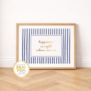 May include: Framed art print with a wooden frame. The print features a white background with navy blue vertical stripes. A white rectangle in the center contains the gold text "happiness is right where we are."