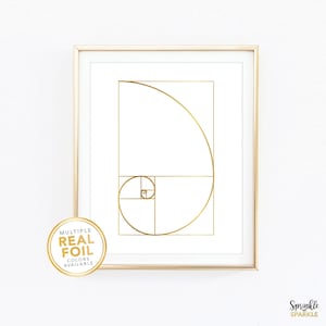 May include: Framed print featuring a gold foil design of the Fibonacci sequence on a white background. The print is in a gold frame and includes a circular sticker that says "Multiple Real Foil Colors Available."