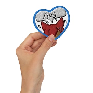 May include: A blue heart-shaped patch with a white speech bubble that says "Joy" and a red cartoon fox inside the heart.