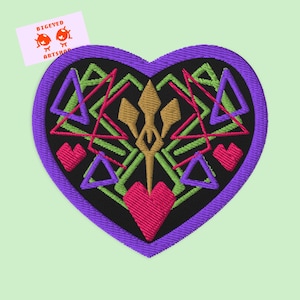 May include: Heart-shaped embroidered patch with a purple border. The black centre features geometric designs in pink, green, and purple, with a gold central element and two pink hearts. The patch has the text "BIGEYED ARTSHOP".