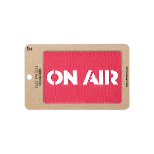 May include: A rectangular red fabric hat patch with a hook velcro backing, featuring the white text ON AIR in a bold, sans-serif font. The patch is mounted on a light brown cardboard display card with the text HAT PATCH WITH HOOK VELCRO.