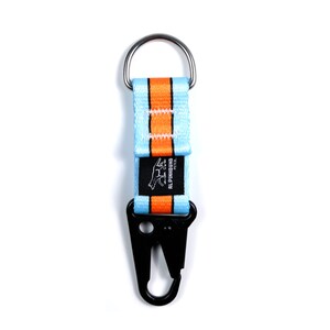 Pu&ograve; includere: Un portachiavi a strisce blu e arancioni con un moschettone in metallo nero e un piccolo logo nero che dice "ALPHINHOUNd ESTD."