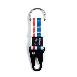Pu&ograve; includere: Portachiavi a strisce bianche e blu con un moschettone nero e un'etichetta logo nera che dice "Alpinhound Piece."