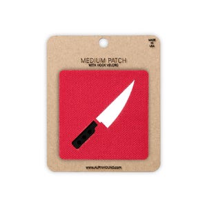 May include: A red medium patch with a white knife graphic and black handle. The patch is attached to a cardboard backing with the text "MEDIUM PATCH WITH HOOK VELCRO" and "MADE IN USA". The website address www.alpinhound.com is printed at the bottom.