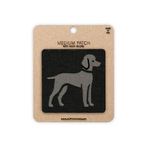 以下が含まれることがあります： 中型の黒いパッチで、ベルクロが付いており、犬の灰色のシルエットが特徴です。 パッチは、"MEDIUM PATCH WITH HOOK VELCRO"と"MADE IN USA"のテキストが入ったタン色の段ボールの裏地の上にあります。 ウェブサイトのアドレスwww.alpinhound.comが下部に印刷されています。