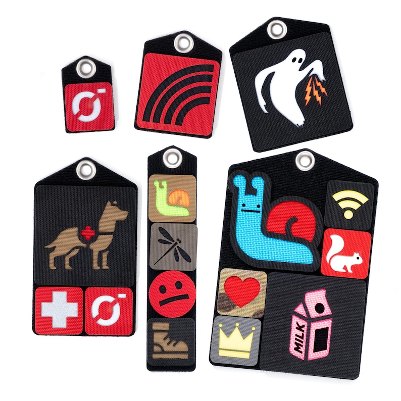 May include: A set of eight black and white fabric patches with various colorful designs. The patches feature a rainbow, a ghost, a dog, a snail, a dragonfly, a smiley face, a heart, a crown, a milk carton, a squirrel, and a wifi symbol.