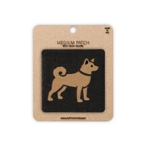 May include: A medium patch with hook velcro featuring a tan Shiba Inu dog silhouette on a black background. The patch is mounted on a cardboard backing with the text "MEDIUM PATCH WITH HOOK VELCRO" and "MADE IN USA". The website address www.alpinhound.com is printed at the bottom.