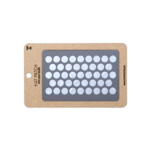 May include: A rectangular gray hat patch with hook velcro backing, featuring a grid of white circular adhesive dots. The patch is mounted on a tan cardboard display card labeled HAT PATCH WITH HOOK VELCRO, MADE IN USA, and ALPHAHOUND.COM.