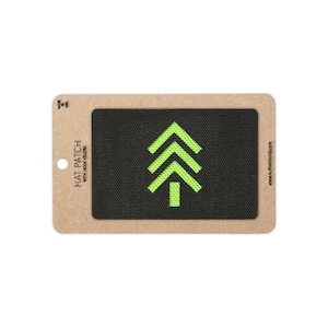 May include: A rectangular black hat patch with a hook velcro backing, featuring a bright neon green embroidered pine tree graphic. The patch is mounted on a tan cardboard display card labeled HAT PATCH WITH HOOK VELCRO and MADE IN USA.