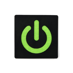 May include: A black fabric patch with a green power button symbol.