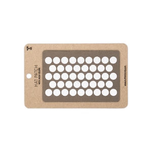 May include: A rectangular brown hat patch with hook velcro backing, featuring a grid of white circular cutouts. The patch is mounted on a tan cardboard display card labeled HAT PATCH WITH HOOK VELCRO and MADE IN USA.